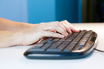 Close up woman typing at computer keyboard working from home