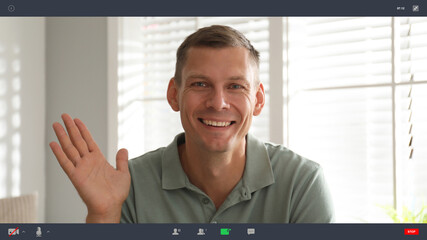 Wall Mural - Man communicating with coworkers from home using video chat, view through camera