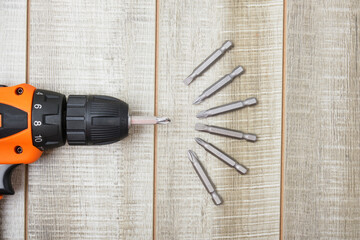 electric screwdriver, self-tapping screws, screwdriver bits, tool box on a wooden background