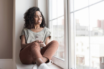 Young woman resting at home with smartphone, beautiful girl looking out of window in her room, Communication, relaxation, connection, lockdown, technology, leisure lifestyle concept