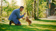 © Gorodenkoff - Handsome Man Plays with Cute Little Pomeranian Dog, Training, Teaching Tricks and Commands in the Suburb Backyard. Sunny Day with Green Grass Having Fun with Man's Best Friend.