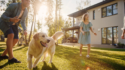 Smiling Beautiful Family of Four Play Catch flying disc with Happy Golden Retriever Dog on the Backyard Lawn. Idyllic Family Has Fun with Loyal Pedigree Dog Outdoors in Summer House.