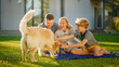 © Gorodenkoff - Portrait of Father, Mother and Son Having Picnic on the Lawn, Posing with Happy Golden Retriever Dog. Idyllic Family Has Fun with Loyal Pedigree Puppy Outdoors in Summer House Backyard.