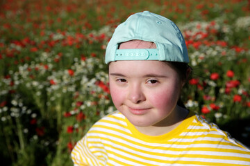 Wall Mural - Young girl on the background of flowers field