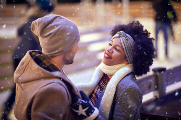 Wall Mural - A young couple in love having romantic moments at ice rink. Skating, closeness, love, together