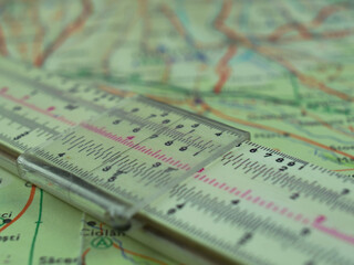 Retro Slide Rule Slipstick Used for Mathematical Calculations Over Old Map