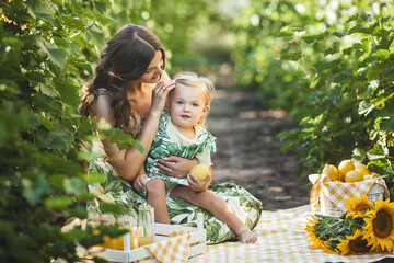 Young attractive mother and her little baby girl outdoors. Pretty family