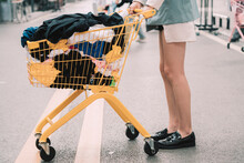 Stylish Woman Pushing Shopping Cart On Street