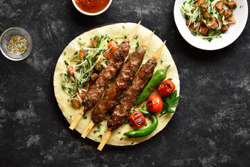 Adana Kebab with fresh vegetables on flatbread