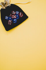 Canvas Print - Vertical of red and blue dice on dice bag isolated on yellow background