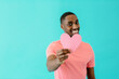 © Carlos David - Portrait of a smiling young man holding pink heart for romantic valentineÕs day