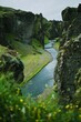 A unique shot of fjaðrárgljúfur canyon in Iceland with a river flowing through with a grassy foreground