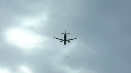 Wall Mural - Slow motion silhouette of a plane fly on cloudy day. A commercial passenger aircraft across flying. Jet airplane take off or landing from international airport-Dan