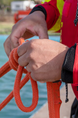 Wall Mural - firefighter hands tying rope knot, vertical photo.