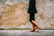 woman in boots walking on the street - copy space