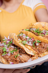 woman holding delicious mexican birria tacos guadalajara style