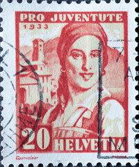 Switzerland - Circa 1933 : a postage stamp printed in the swiss showing the portrait of a Ticino woman in historical costume and a village in Ticino