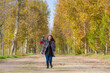 © TheVisualsYouNeed - outdoors lifestyle portrait of young happy and pretty Asian Korean woman walking relaxed and cheerful at beautiful city park in vibrant yellow and orange Autumn tree leaves