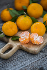 Tangerines with leaves on an old wooden background