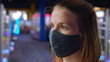 Woman standing in arcade wearing face covering because of COVID-19 virus.