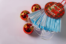 White Christmas Background With Gift Box Full Of Covid Masks And Three Red Christmas Balls