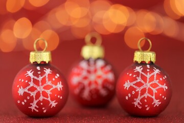 Sticker - Christmas and New Years festive background.Red balls with a snowflake on a bright red glitter background with bright yellow bokeh. Christmas beautiful festive background. Holidays Beautiful wallpaper.