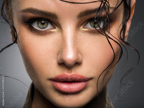 Fotografía Closeup portrait of a beautiful young woman with brown gkamour makeup