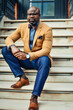 © Mocha Stock - Portrait of confident African American businessman in glasses and tan blazer.