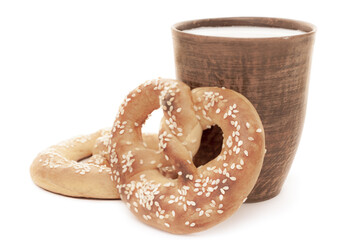 Tasty fresh just from oven crispy two Brezel pretzels with brown ceramic glass of milk isolated on white background retro style