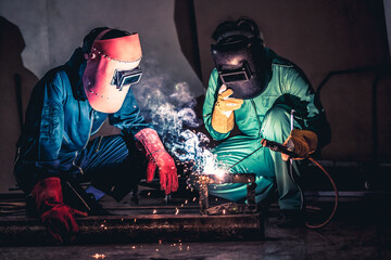 Metal welding steel works using electric arc welding machine to weld steel at factory. Metalwork manufacturing and construction maintenance service by manual skill labor concept.