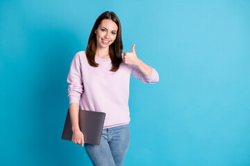 Photo of attractive student lady hold notebook hands modern technology user raise thumb finger up approving good quality wear casual purple sweatshirt jeans isolated blue color background