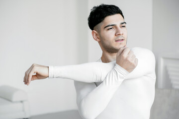 stretching the body a Healthy lifestyle is exercising at home. a young man is quarantined in an apartment. hardy athletic man doing exercises doing sports fitness.