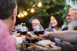 © Alessandro Biascioli - Happy family dining and tasting red wine glasses in barbecue dinner party - People with different ages and ethnicity having fun together
