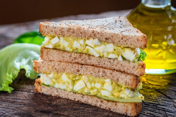 Poster - Sandwich with avocado and egg on wooden background