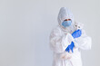 © Михаил Решетников - A woman in a protective suit with gloves and a mask is holding a white cat. Doctor tests pets for coronavirus