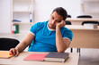 © Elnur - Exhausted male student preparing for the exams in the classroom
