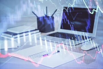 Stock market graph on background with desk and personal computer. Double exposure. Concept of financial analysis.