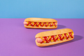 Couple of fresh hot dogs on violet background