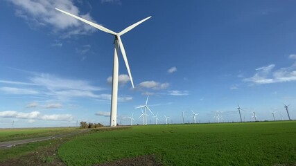 Wall Mural - Wind farm turbines that produce electricity energy. Windmill Wind power technology productions Wind turbines standing in green field - stock footage