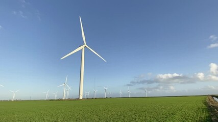 Wall Mural - Wind turbines that produce electricity energy. Windmill Wind power technology productions Wind turbines standing in green field - stock photo