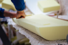 Vertical Shot Of A Furniture Maker Shaping An Upholstery Foam