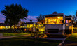 Rving at a resort in the evening lighted sky with class A rigs interior lights on