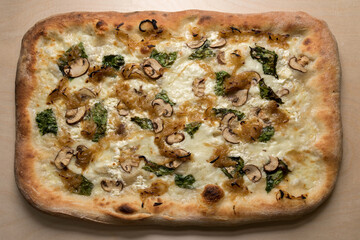 Wall Mural - Italian square pizza with mushrooms, mozzarella, cooked onions and basil leaves, top view on wooden background before cutting