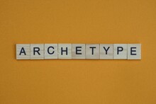 Gray Word Archetype Made Of Wooden Square Letters On Brown Background