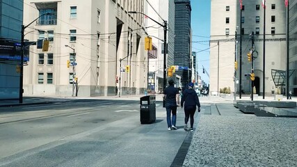 Wall Mural - Toronto, Ontario, Canada - 20 January, 2020: A looping segment of pedestrians in Toronto financial district crossing busy intersection where three major Canadian banks are located.