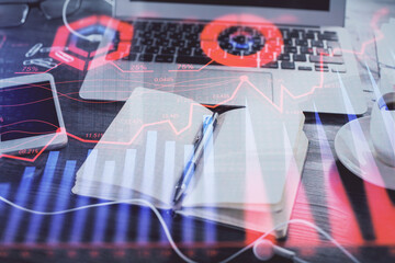 Multi exposure of financial graph drawings and desk with open notebook background. Concept of forex