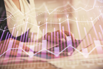 Double exposure of businesswoman hands typing on computer and forex graph hologram drawing. Financial analysis concept.