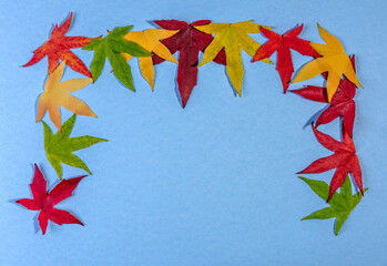 Wall Mural - Autumn leaves forming an arch on a blue background 