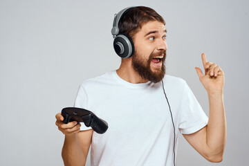 Wall Mural - Man in headphones with gamepad playing hobby entertainment lifestyle light background