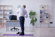 © Elnur - Aged male employee doing physical exercises during break